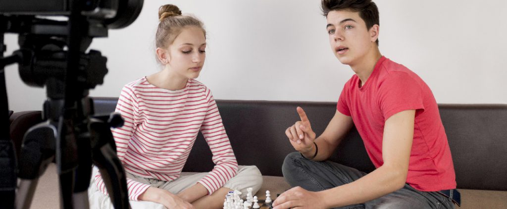 Boy and girl are explaining chess on camera