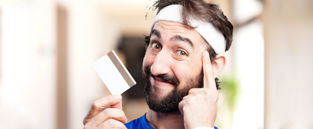 Smiling male with white credit card encourages smart payments