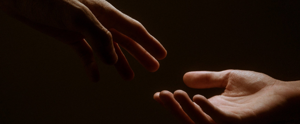 Symbolic photo of two hands illustrating someone on touch