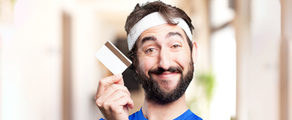 Tennis trainer smiling while holding credit card