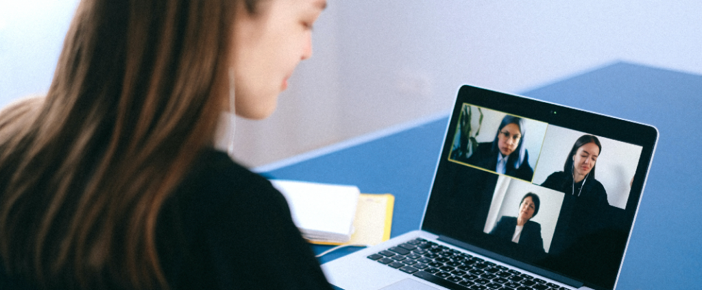 Woman video calling with her co-workers via laptop