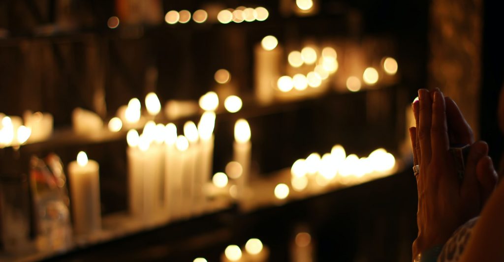 Woman praying in church with candles